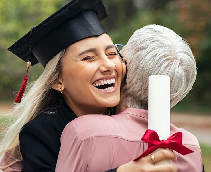 Happy graduate hugging family member